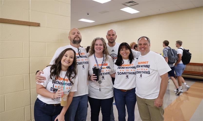 A group of teachers smiles
